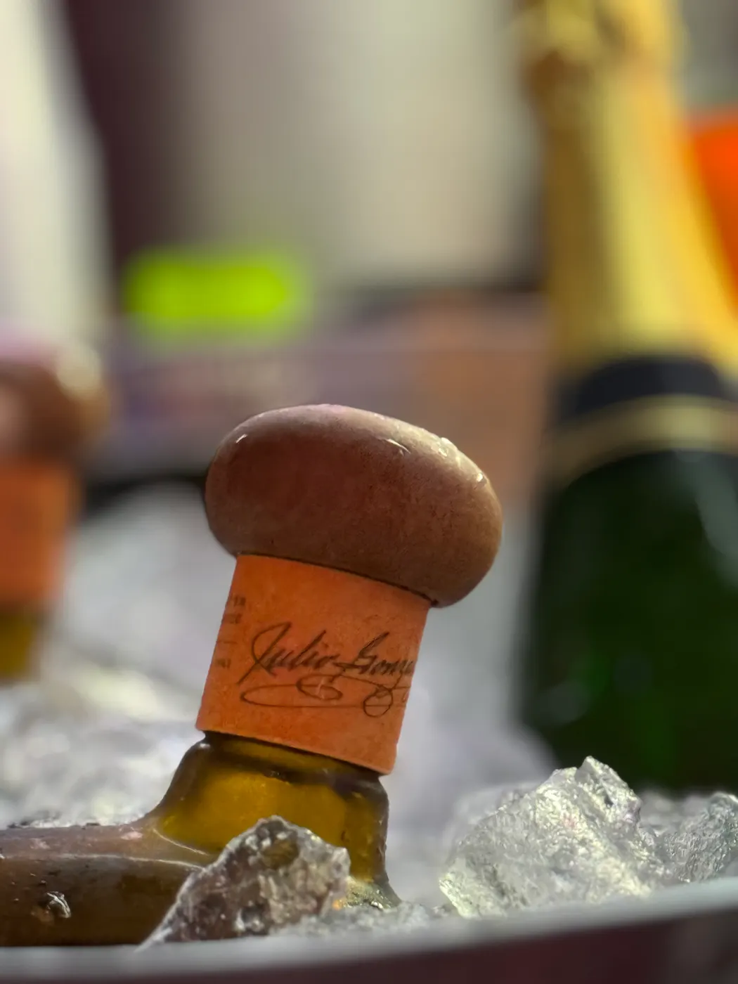 Close up of bottle of tequila resting in a bucket of ice. 