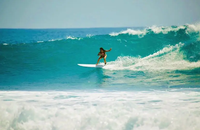 Surfer getting low as they coast through a wave at Zippers Beach in San Jose del Cabo Mexico. 