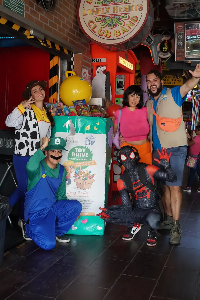 Characters next to toy donations for Children's Day party at El Squid Roe.