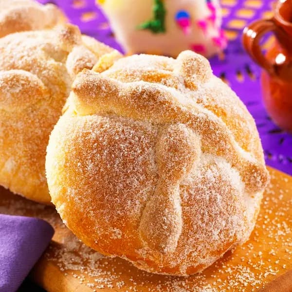 Round bread with a cross over it, covered in sugar.