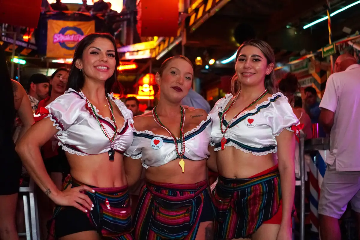Three women with traditional mexican skirts and white crop tops. at the Viva Mexico event at El Squid Roe. 