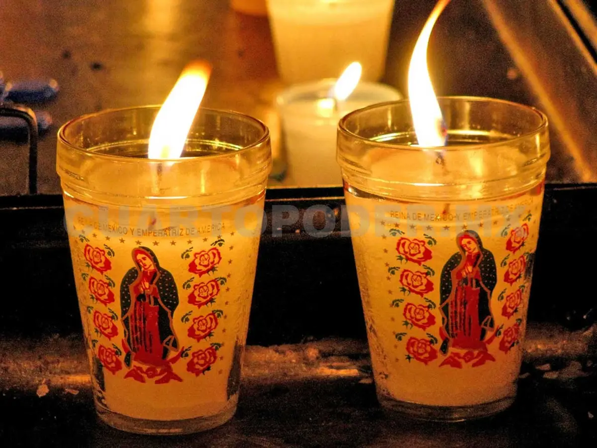 Two lit candles, each with the Virgin of Guadalupe. 