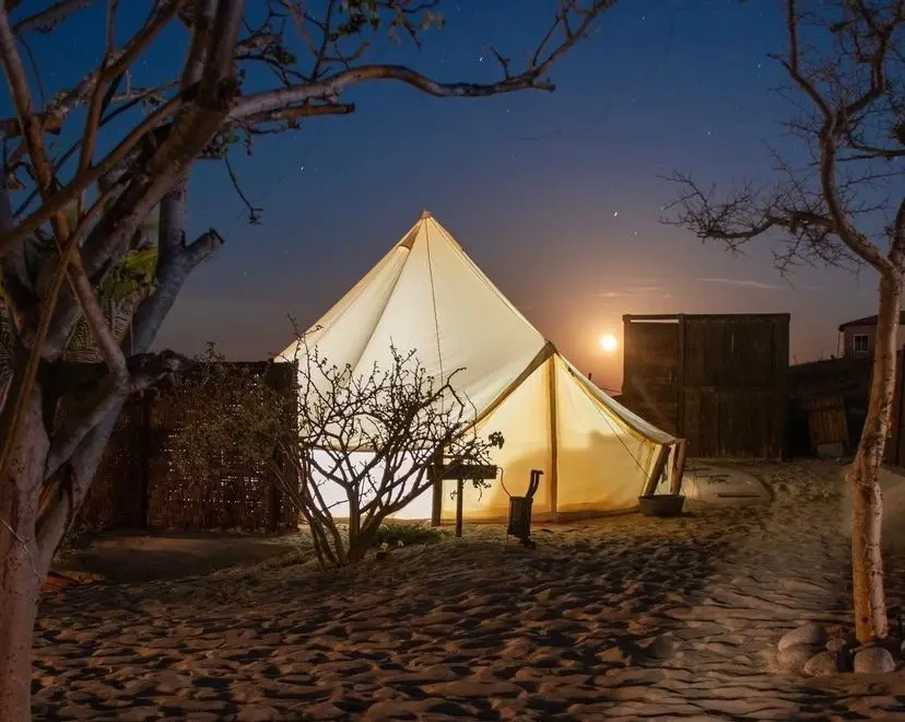 Glamping tent light up in under the night sky. 