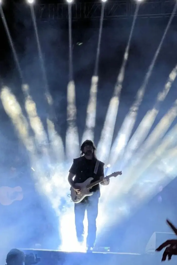 Juan Esteban Aristizábal Vásquez, lead singer of Juanes, playing the guitar in stage, lights and smoke behind him in Cabo, Mexico. 
