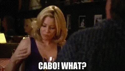  Sal from Modern Family slamming a shot glass while she screams "Cabo!" as Mitch and Cam look shocked and ask "What?"