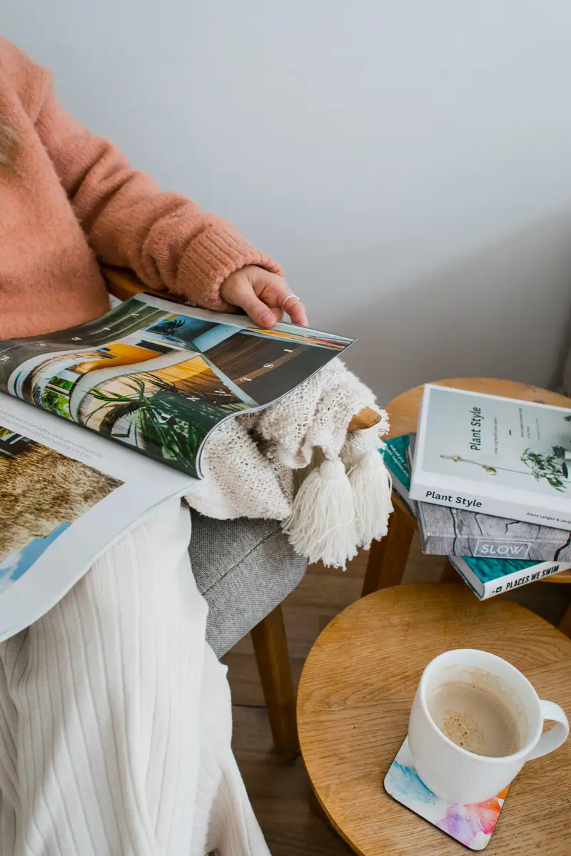 Taking a break to read a magazine and have a cup of coffee.