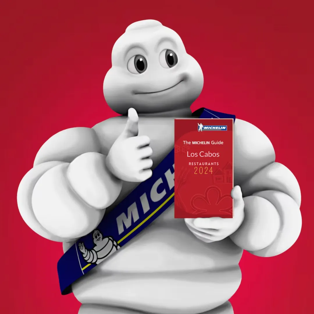 Michelin man holding a Los Cabos 2024 Michelin guide.  