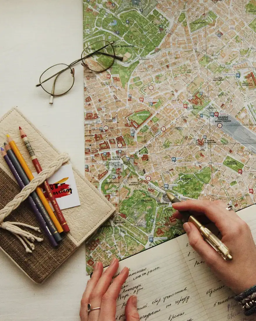 planning a trip with a map, notebook and colored pencils.