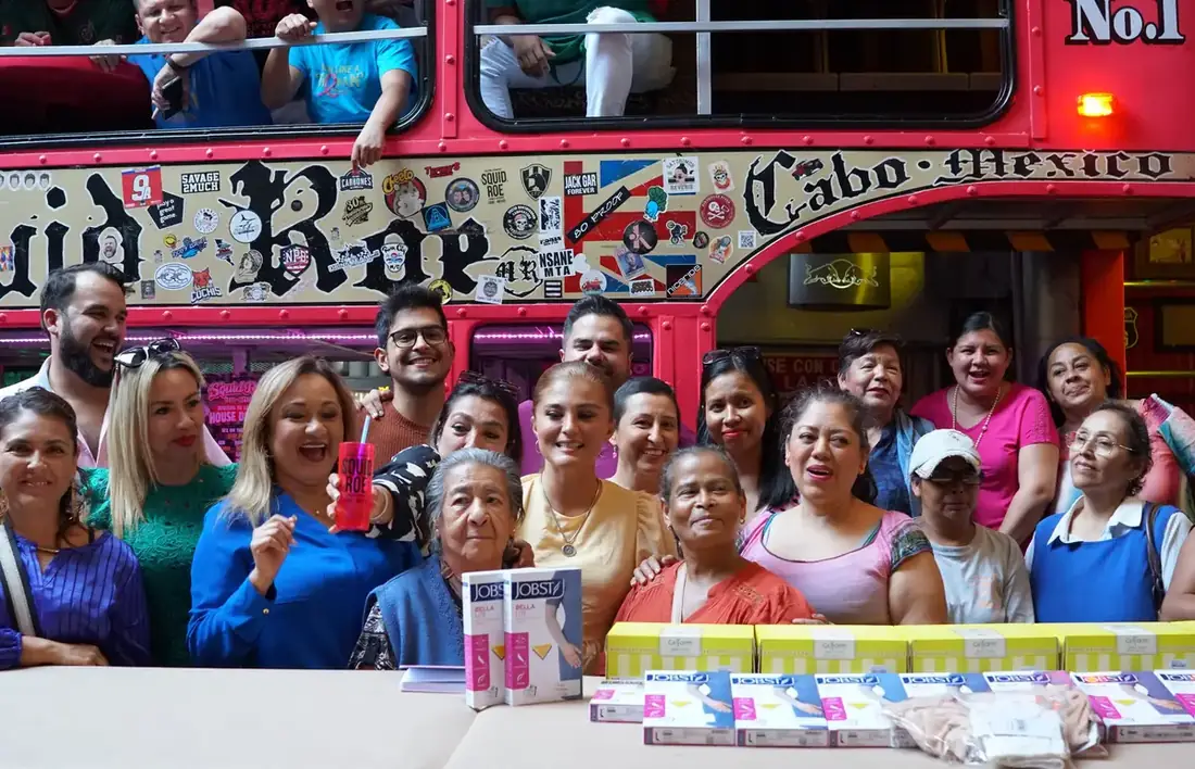 Group of women and Breast Cancer Society Foundation gathered around a table with medicine and braces. 