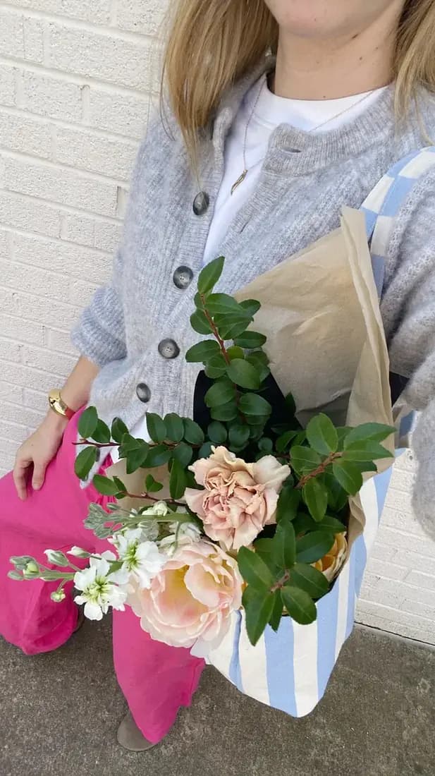 Woman using her reusable bag to tote around her purchases. 