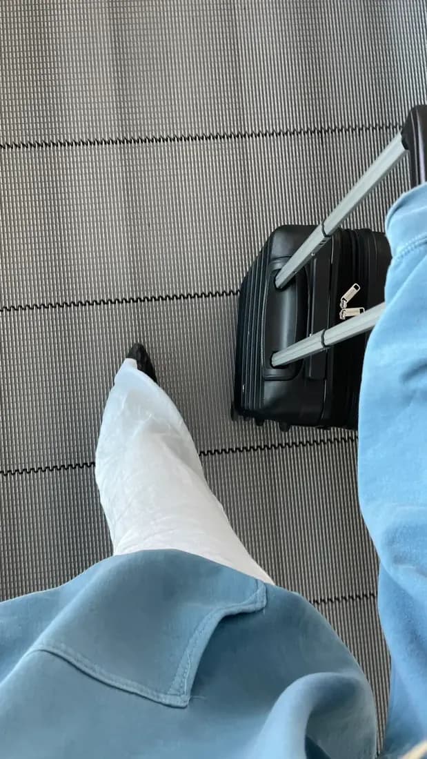 Woman with her carry-on on the moving walkway in an airport.