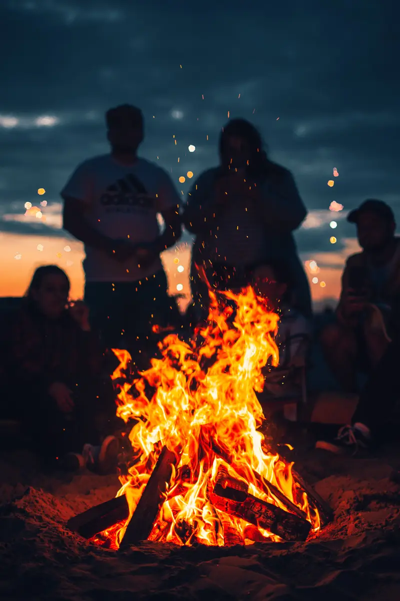 People surrounding a bonfire at the beach in Cabo, Mexico.