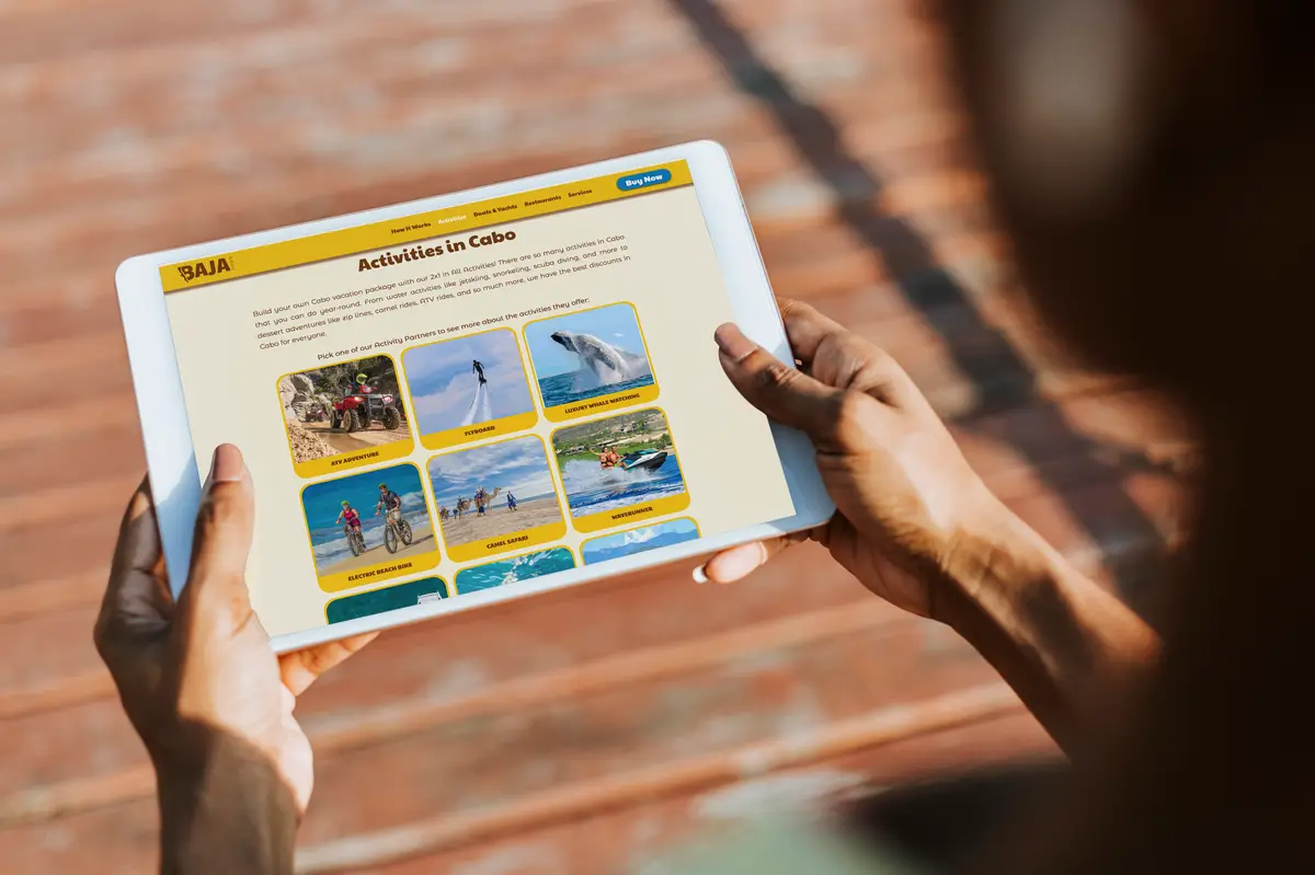 Person holding their tablet, looking at the Baja Pass website.