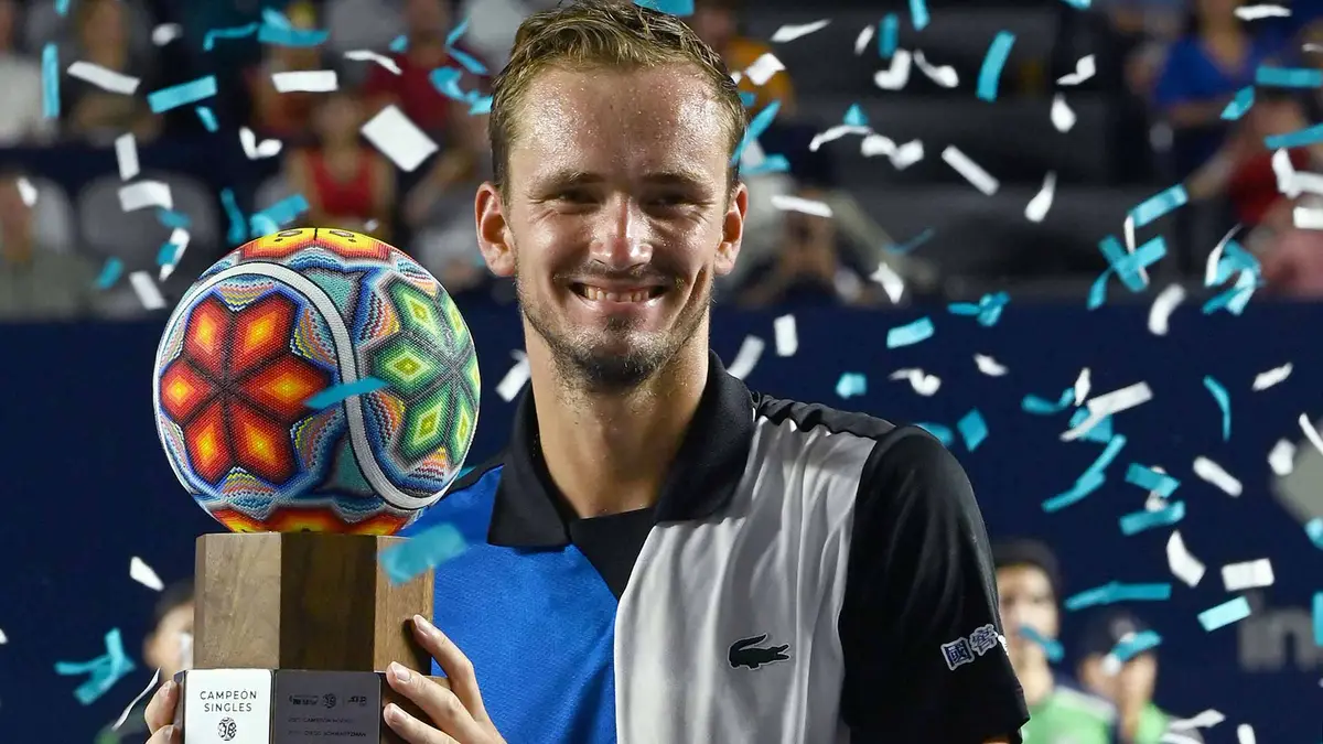 Daniil Medvedev holding the Single's Trophy, confetti flying in the background.