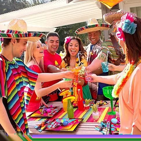 Group of friends dressed in ponchos and sombreros toasting.