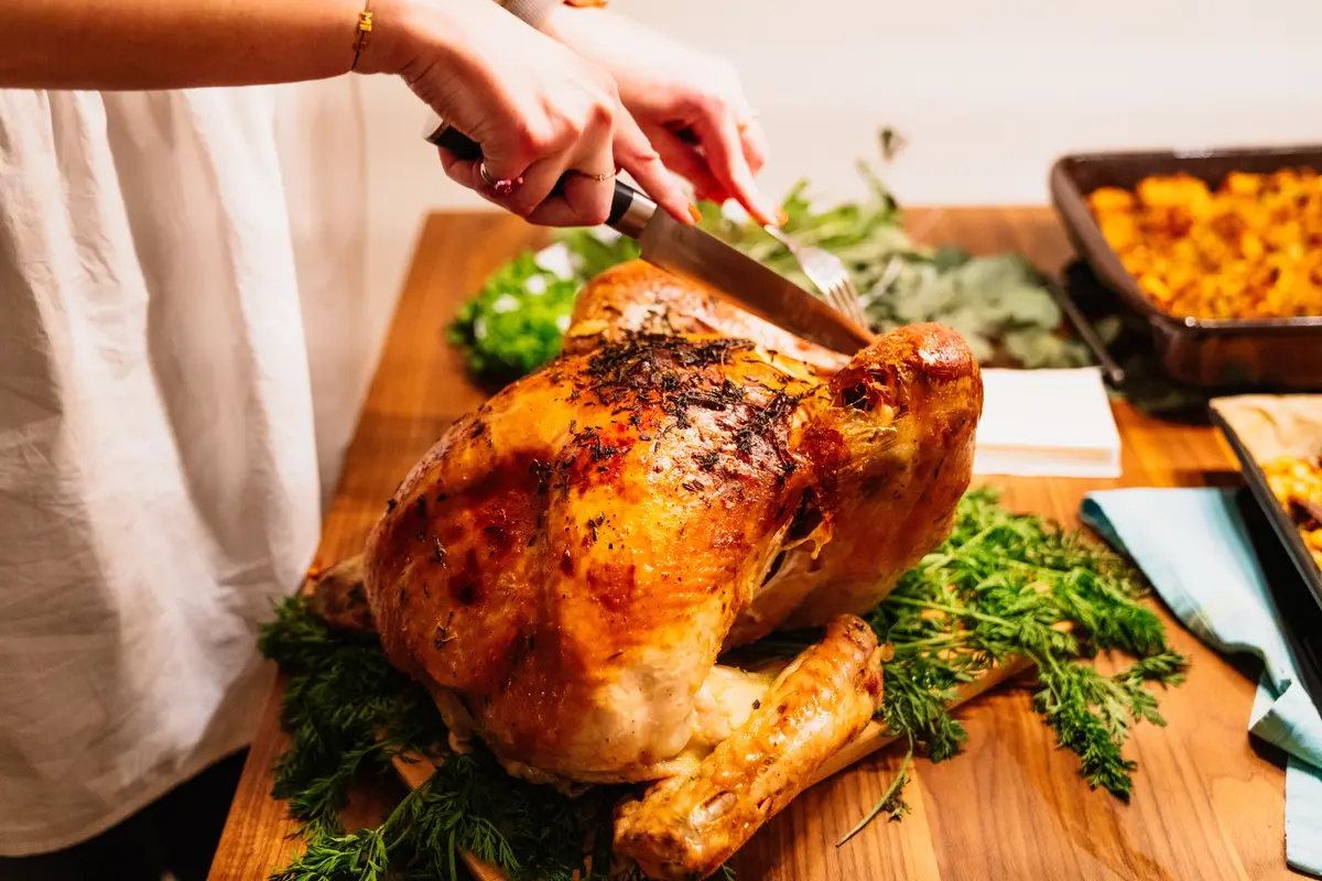 Turkey being carved on the dinner table.