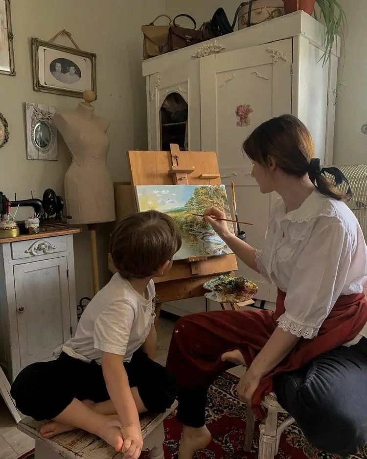 Mother painting with her son besides her.