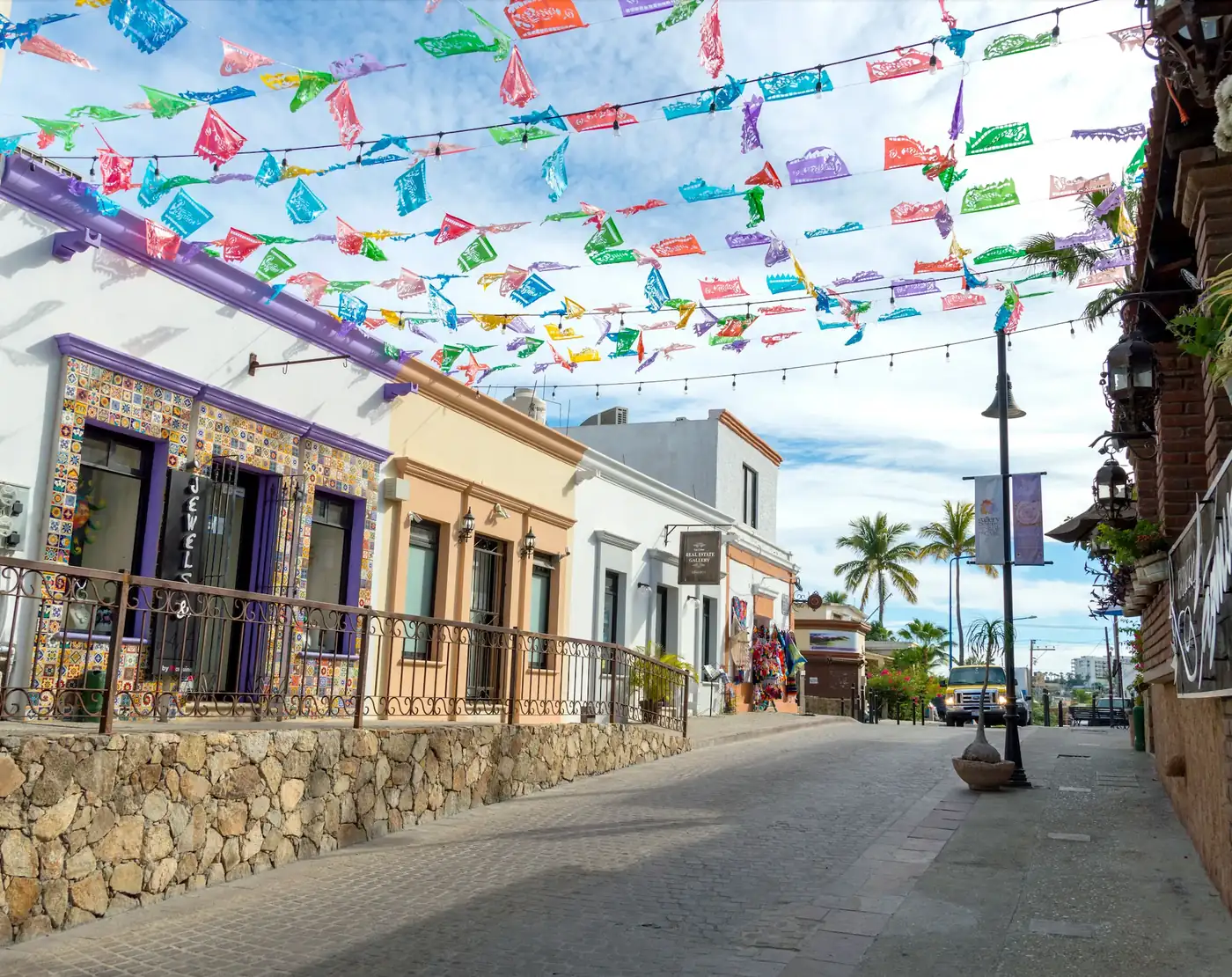 San Jose street lined with buildings, colorful papel picado from side to side of the street.