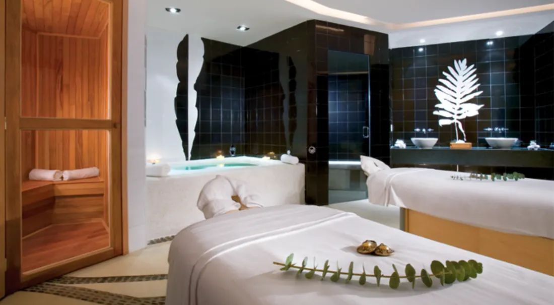 Massage tables covered nicely with towels, a steam room in the background.