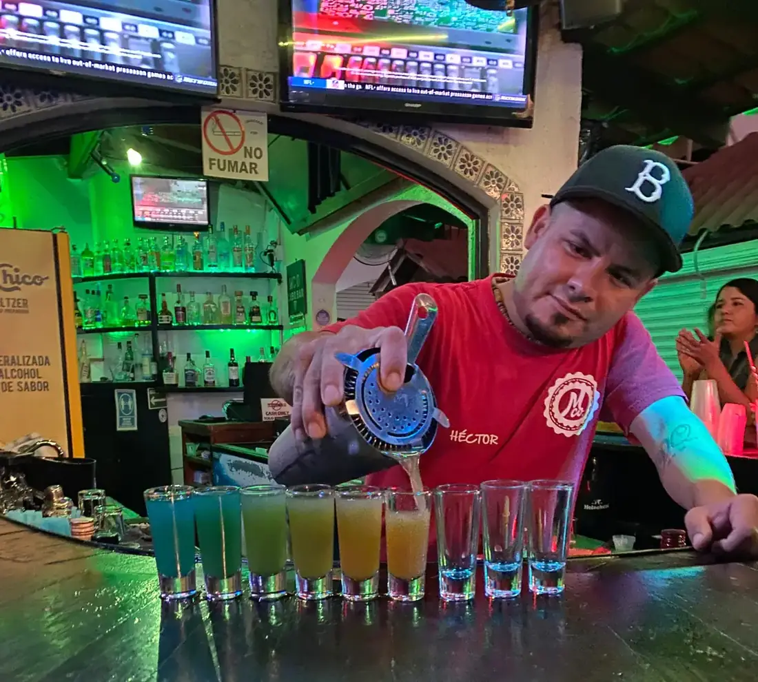 Bartender pouring rainbow shots.