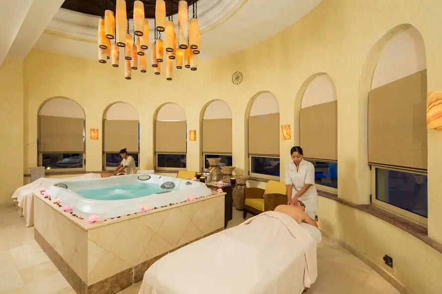 Two people getting a massage with a hot tub between them.