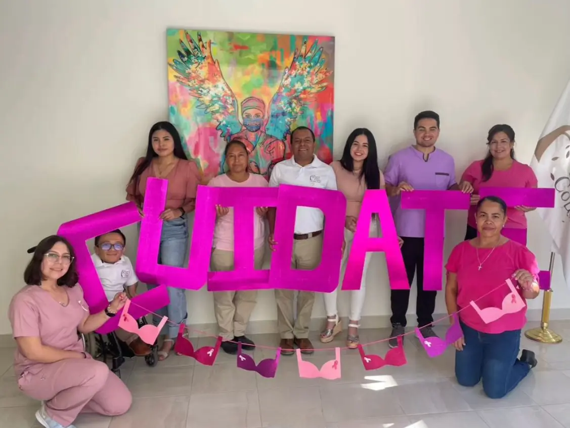 Fundación Letty Coppel volunteers holding up pink letters saying "take care of your self" in Spanish.