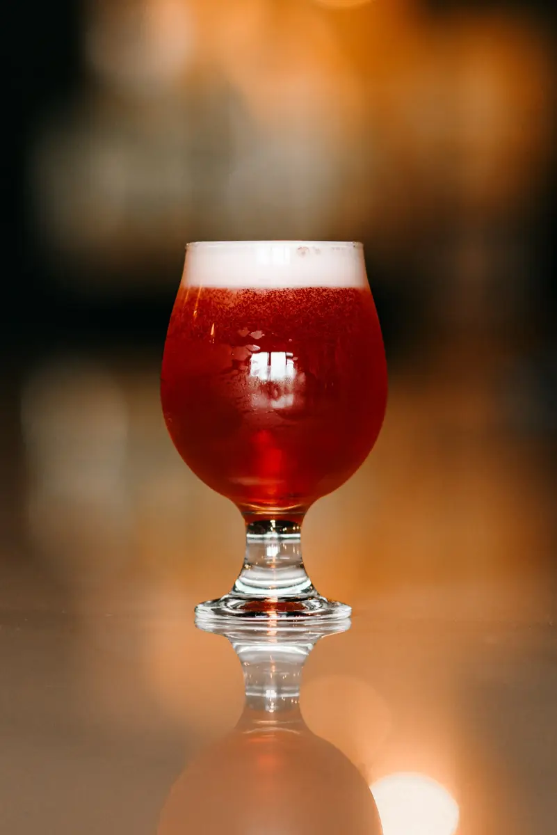 Glass of Amber Beer resting on a bar.